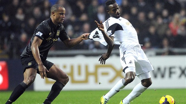 Roland Lamah (vpravo) ze Swansea faulovan  Vincentem Companym z Manchesteru City.