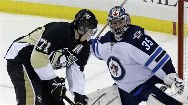 Jevgenij Malkin (vlevo) z Pittsburghu se pokou pekonat glmana Ala Montoyu z Winnipegu.