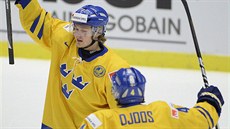Švédští hokejisté Lucas Wallmark a Christian Djoos se radují z gólu.