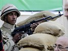 Voják kontroluje frontu lidí ekající venku ped volební místností v Káhie pi...