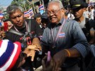 Bývalý vicepremiér Suthep Thaugsuban (v proukované koili) se zdraví s...