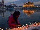 Dívka zapaluje svíky na behu u Zlatého chrámu v Amritsaru, které je centrem a...