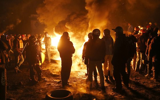 Opoziní demonstranté se zahívají u jedné z barikád v Kyjevu