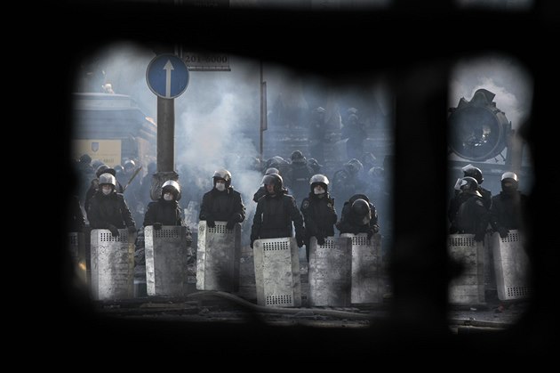 Policejní jednotky p�i pohledu skrz barikádu p�íznivc� opozice (Kyjev, 26....
