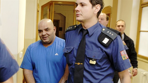 Eskorta k soudu přivádí jednoho ze čtyř útočníků z trestné výpravy v Duchcově Ladislava Feriho.