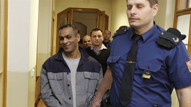 Eskorta k soudu přivádí jednoho ze čtyř útočníků z trestné výpravy v Duchcově Jaroslava Ferka, za ním David Bledy.