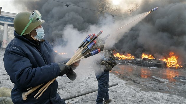 Situace v ulicch Kyjeva pipomn vlku. Demonstranti odpaluj proti policistm zbavn pyrotechniku. (23. ledna 2014)