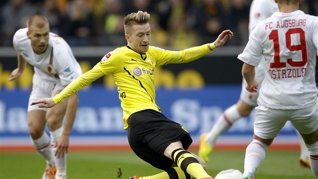 Marco Reus z Dortmundu (ve lutm) v boji o baln bhem duelu proti Augsburgu