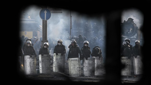Policejní jednotky při pohledu skrz barikádu příznivců opozice (Kyjev, 26. ledna 2014).