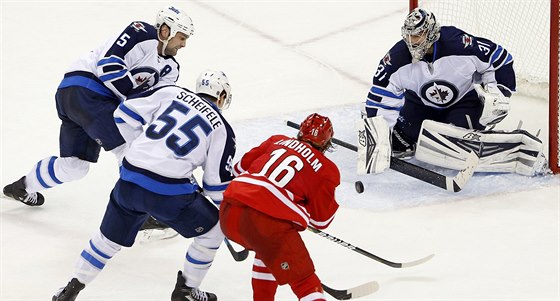 Branká Ondej Pavelec z Winnipegu sleduje, jak dopadne souboj jeho spoluhrá...