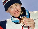 Luká Bauer stojí na stupních vítz s bronzovou medailí po závod na 15 km