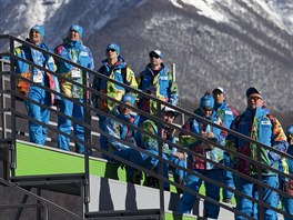 Olympijtí dobrovolníci sledují trénink skokan na lyích ve stedisku Krasnaja...