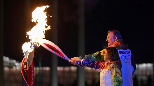 Olympijsk ohe v Soi zaehly spolenou rukou legendy dvou nejoblbenjch ruskch sport: hokejov brank Vladislav Trejak a krasobruslaka Irina Rodninov.. (7. nora 2014)