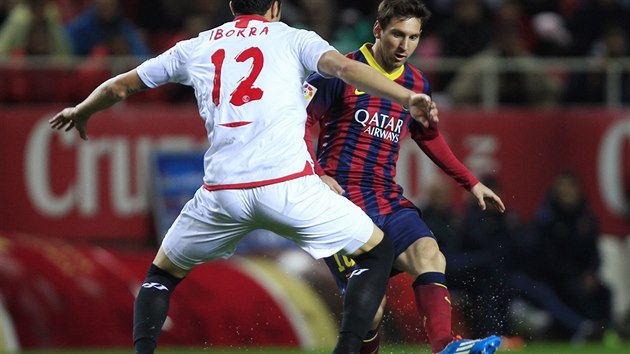 TAK JAKOU KULIRNU VYMYSLM? tonk Barcelony Lionel Messi (vpravo) zkou vyzrt na Vincenteho Ibboru z FC Sevilla.