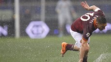 Francesco Totti z AS ím padá na podmáený trávník Olympijského stadionu.