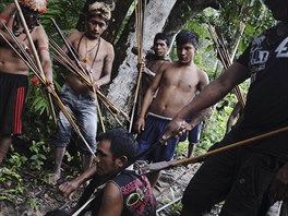 Munduruku Indian warriors stand guard over an illegal gold miner in western...