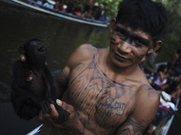 A Munduruku Indian warrior carries a monkey he hunted for food during a search...