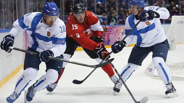 Kanadsk tonk Ryan Getzlaf se probj finskou obranou v utkn olympijskho turnaje v Soi. 