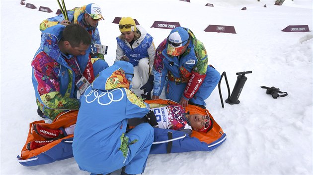 Zdravotnci oetuj nskho bce na lych Wen-lung Sa, kter se zranil pi kvalifikanm sprintovm zvodu v olympijskm stedisku Laura Cross Country. (11. nora 2014)