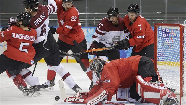 SKRUM. vcarsk glman Jonas Hiller se v duelu s Lotyskem sna zkrotit puk.