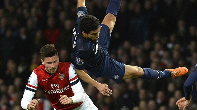 VZDUN AKROBACIE. Rafael z Manchesteru United (vpravo) a Olivier Giroud z Arsenalu se bhem vzjemnho stetnut dostali do krkolomnch pozic.