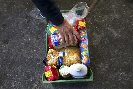 Julio Ortiz skládá do koíku potraviny, které mu dali nakupující. Ve, co se...