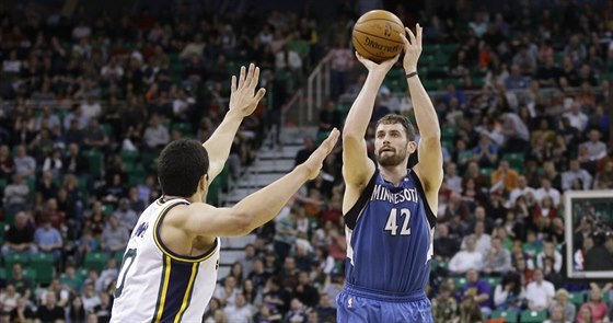 Kevin Love (42) z Minnesoty stílí pes nataené ruce Enese Kantera z Utahu.