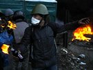 Opoziní demonstrant se chystá hodit zápalnou lahev smrem k policistm na...