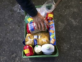 Julio Ortiz skládá do koíku potraviny, které mu dali nakupující. Ve, co se...