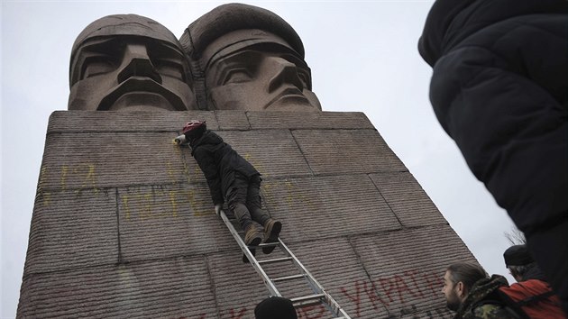 Ukrajinci píší sprejem na pomník KGB v Kyjevě (24. února 2014)