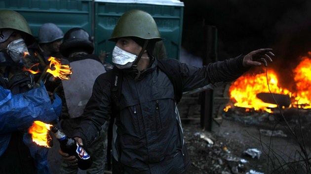 Opozi�n� demonstrant se chyst� hodit z�palnou lahev sm�rem k policist�m na n�m�st� Nez�vislosti v centru Kyjeva. (20. �nora 2014)