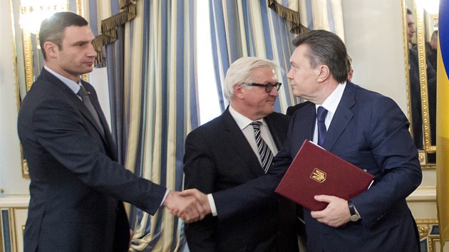 Ukrajinsk prezident Viktor Janukovy (vpravo) a pedk opozice Vitalij Kliko si podvaj ruce po podpisu smlouvy o smru. (21. nora 2014)