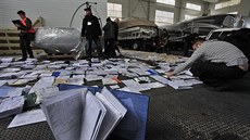 Noviná�i a dobrovolníci su�í a archivují dokumenty, které na�li u Janukovy�ova...