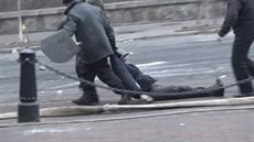 Demonstranti táhnou zraněného kolegu v Kyjevě.