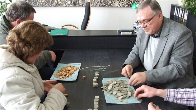 Starosta Prahy 12 Petr Prchal (vpravo) počítá se svými kolegy mince z nalezeného pokladu v Modřanech