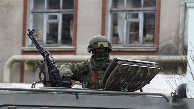 Ozbrojený voják vyhlíží z ruského armádního vozidla v Krymské Balaklavě.