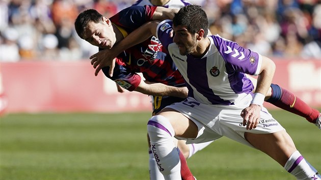 ANI MILIMETR PROSTORU. tonk Barcelony Lionel Messi (vlevo) nedostv v souboji se Stefanem Mitroviem z Valladolidu nic zadarmo.