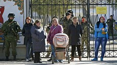 Píbuzní ukrajinských voják (v pozadí) stojí ped bránou areálu v Perevalném,...