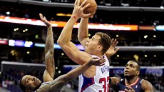 Blake Griffin (uprosted) z Los Angeles Clippers se snaí prosadit pes bránící...