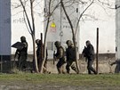 Rutí ozbrojenci prohledávají okolí ukrajinské základny v Simferopolu. Pi...