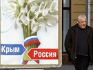 Mu prochází v Simferopolu kolem plakátu s nápisy Krym a Rusko. (12. bezna...