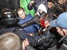 Policisté odvádjí mue zranného pi potykách v Doncku (13. bezna 2014).