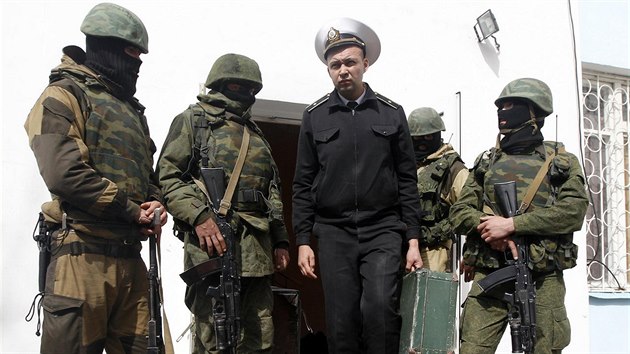 Sbal si kufr a jdi. Maskovaní ozbrojenci vyvádí důstojníka ukrajinského námořnictva ze základny v Sevastopolu. (19. března 2014)