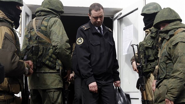 Maskovan ozbrojenci vyvd dstojnka ze sdla ukrajinskho nmonictva v Sevastopolu. (19. bezna 2014)