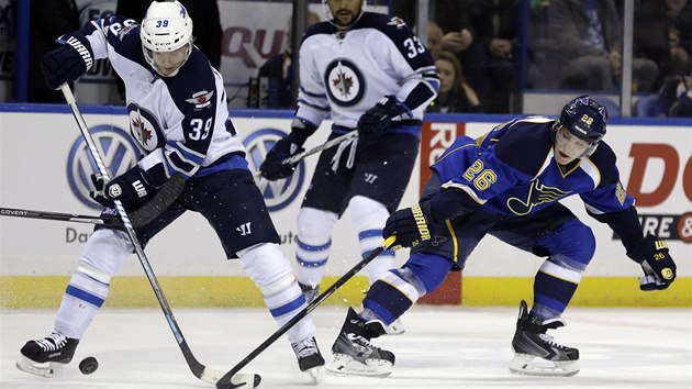 SOUBOJ O PUK. Dmitrij Jakin ze St. Louis (vpravo) a Tobias Enstrm z Winnipegu v souboji.