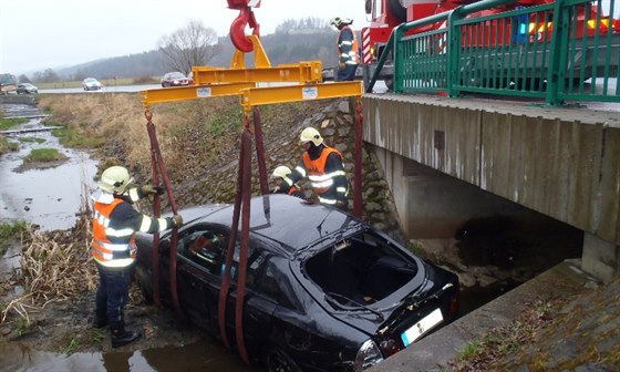 Automobil se dvma pasaéry skonil na boku v potoce pod mostkem (23. bezna...