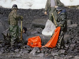 11In this April 2, 1989, file photo, workers try to remove globs of oil from...