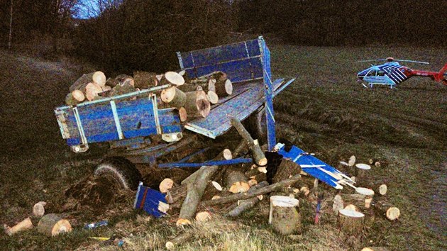 Traktor se převrátil kvůli stočení připojené vlečky se dřevem.