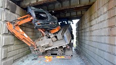 Řidič nákladního auta s bagrem na korbě se nevešel pod viadukt v Nebanicích.
