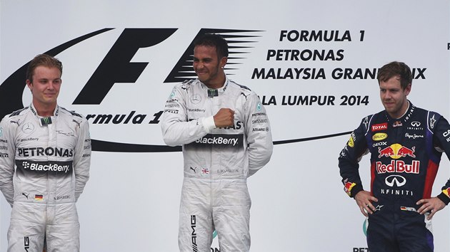 VTZ JSEM J. Lewis Hamilton se tlue do srdce na oslavu vtzstv ve Velk cen Malajsie. Vlevo je jeho kolega Nico Rosberg, vpravo Sebastian Vettel, kter si dojel pro tet msto.